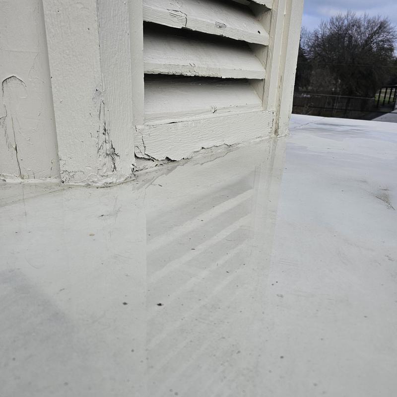Roof vent base with cracked paint and hail damage