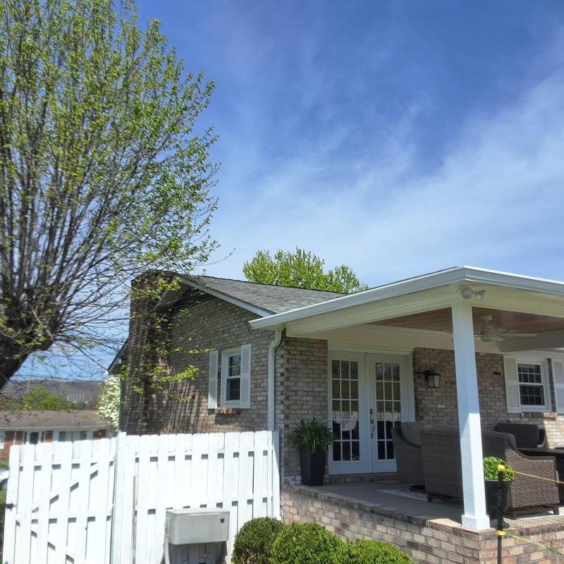 Asphalt shingle roof on brick house with covered porch