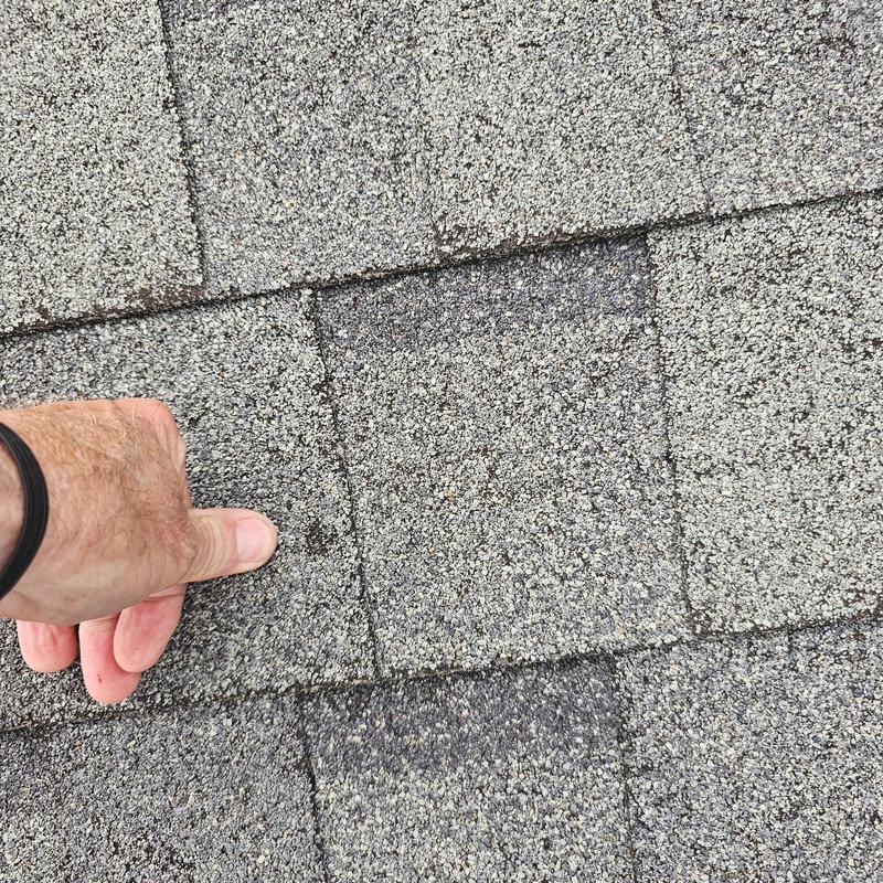 Asphalt roof shingles with hail damage close-up