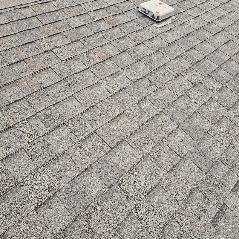 Asphalt shingle roof with hail damage and vent cover