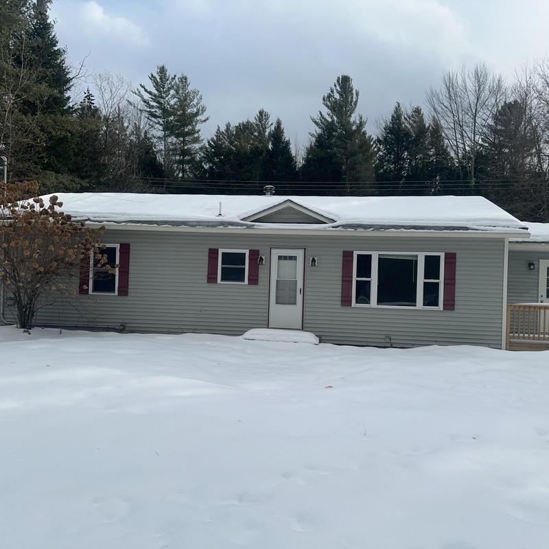 Asphalt shingle roof on snow-covered house in winter