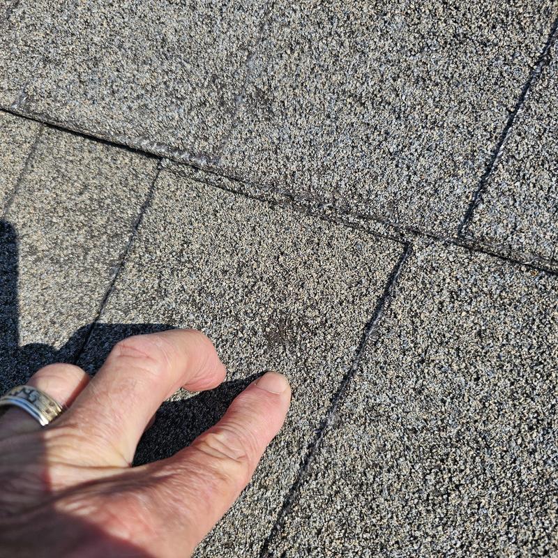 Asphalt roof shingle with hail damage close-up