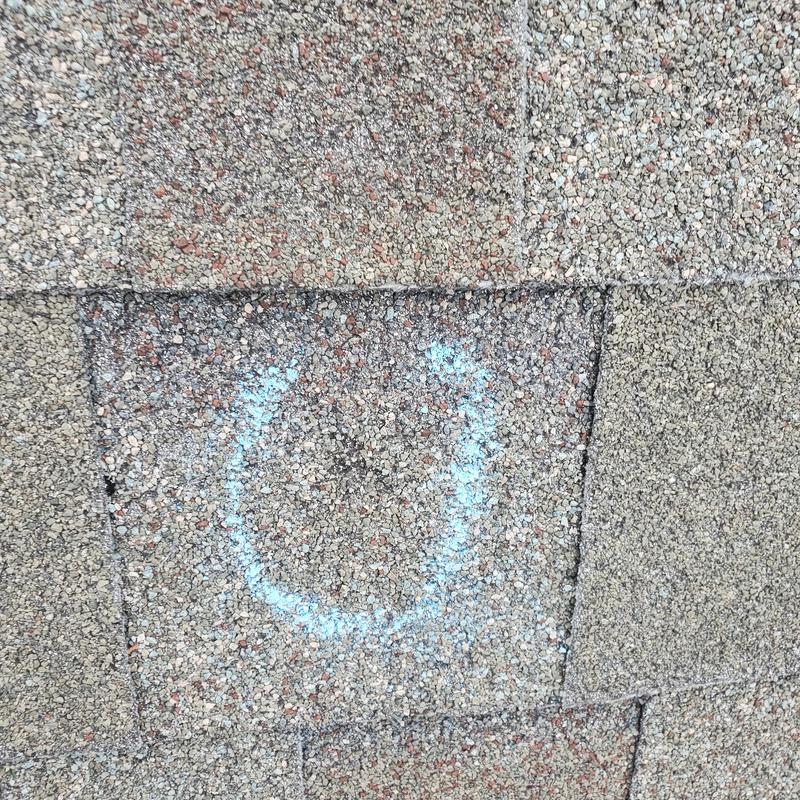 Asphalt roof shingle damage marked from hailstorm