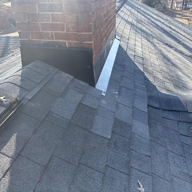 Chimney flashing system with metal apron on asphalt roof