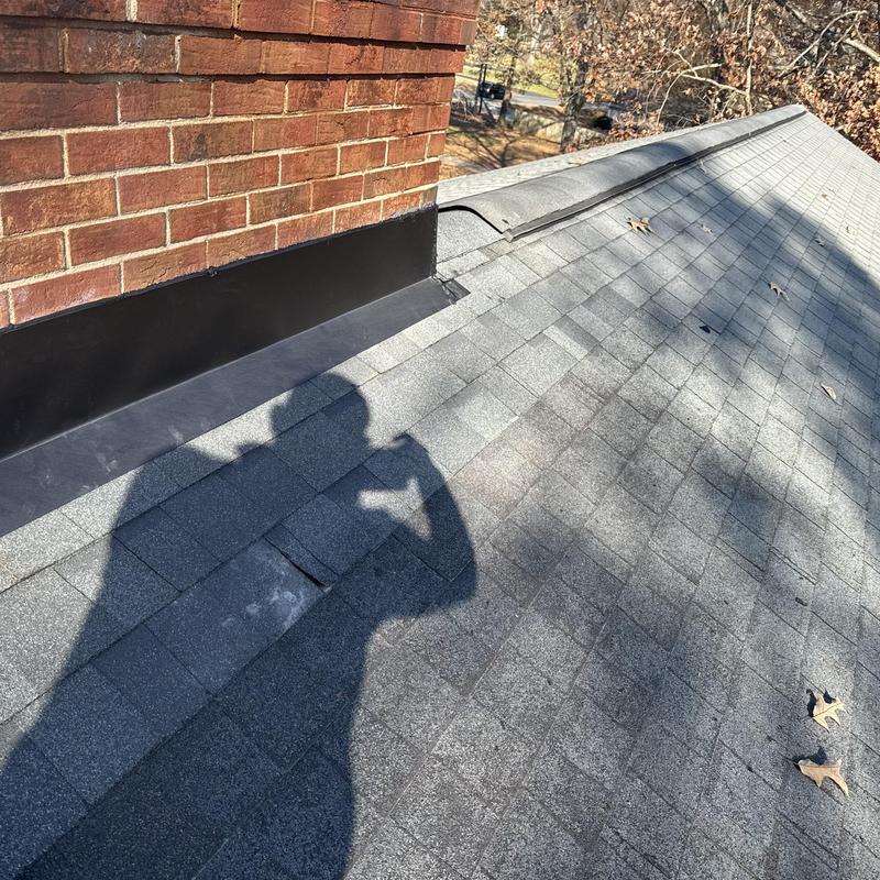 Masonry chimney metal flashing on asphalt shingle roof