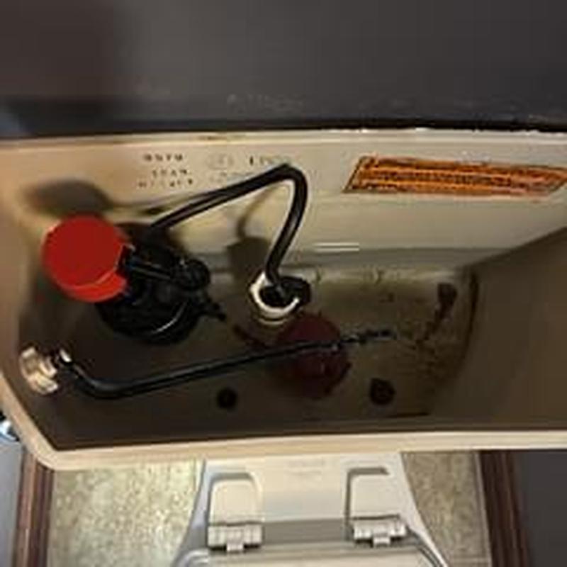 Toilet tank with rebuilt flush valve assembly