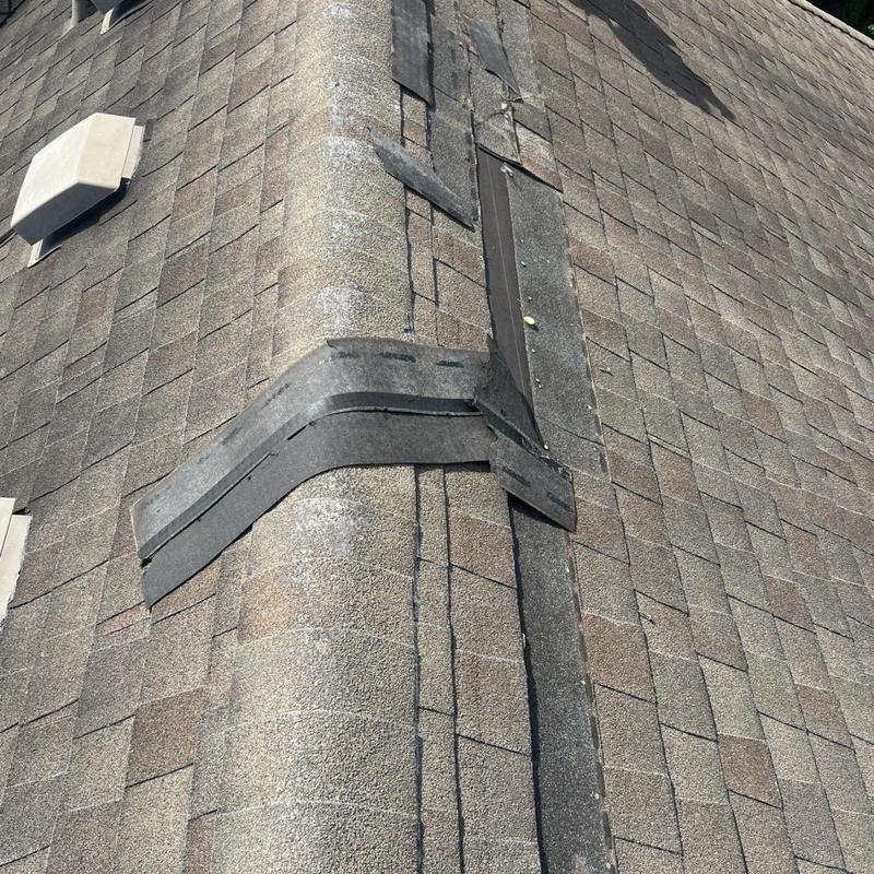 Ridge cap shingles with flashing on roof peak