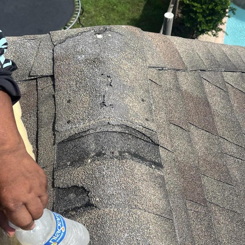 Ridge cap shingles with damage on residential roof