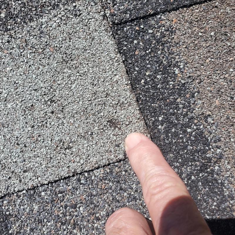 Asphalt roof shingle with hail damage close-up