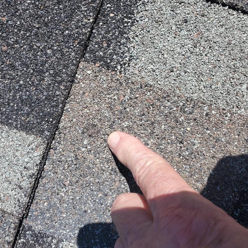 Asphalt roof shingle with hail damage closeup