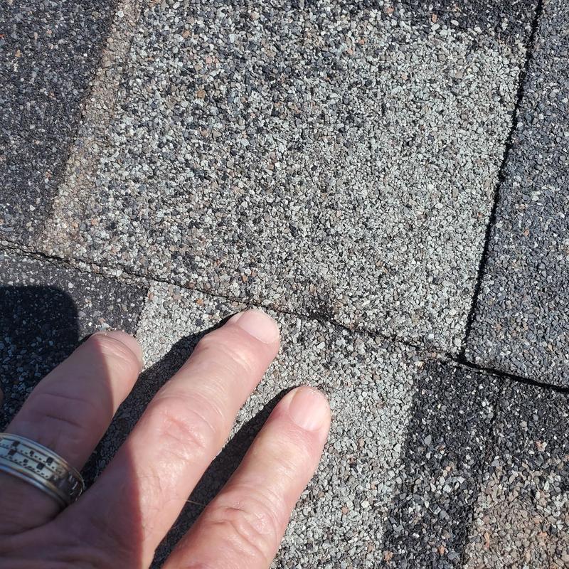 Asphalt roof shingles showing hail damage close-up
