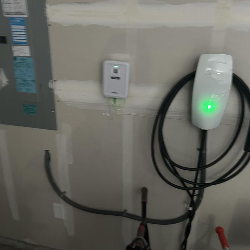 Electric vehicle charger installation with electrical panel in garage