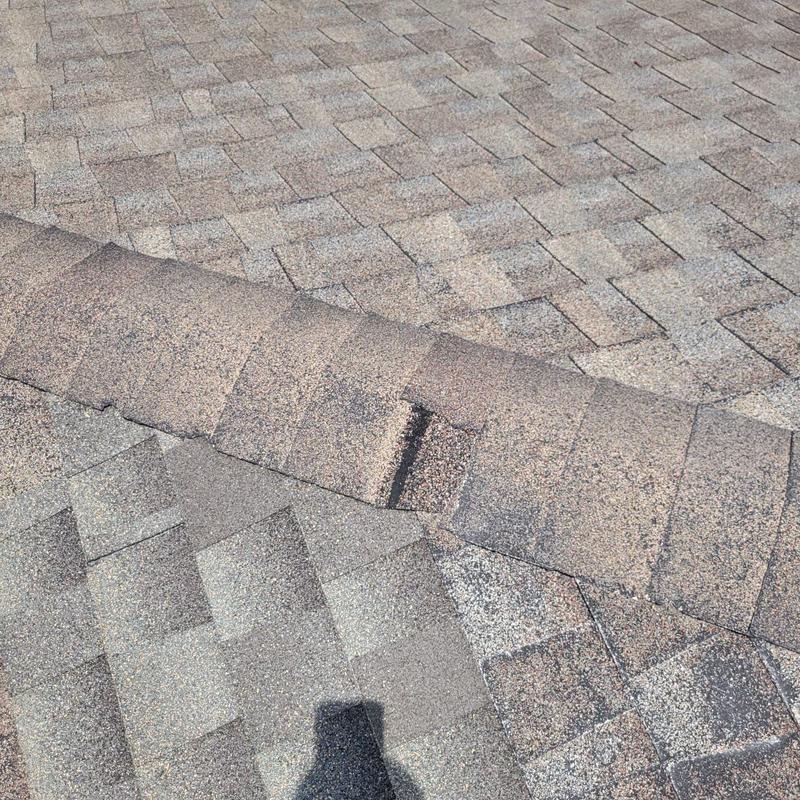 Roof ridge shingles with visible damage and wear