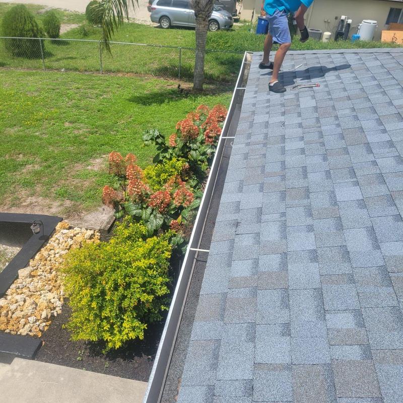 Gutter system installation on new roof shingles
