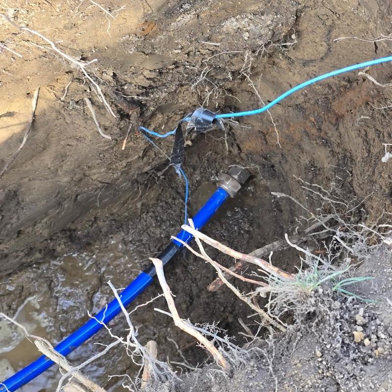 Water service line with blue piping in trench