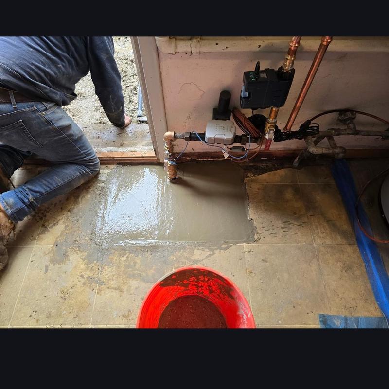 Water service line with cement patching near doorframe