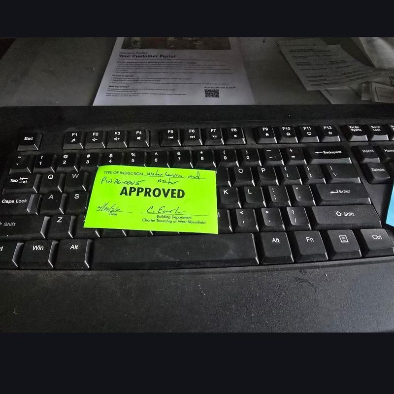 Water service and meter inspection approval sticker on keyboard