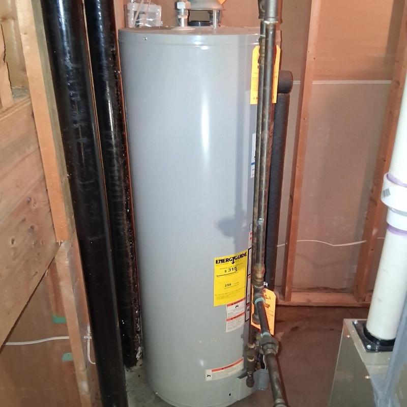 Water heater with attached plumbing pipes in basement