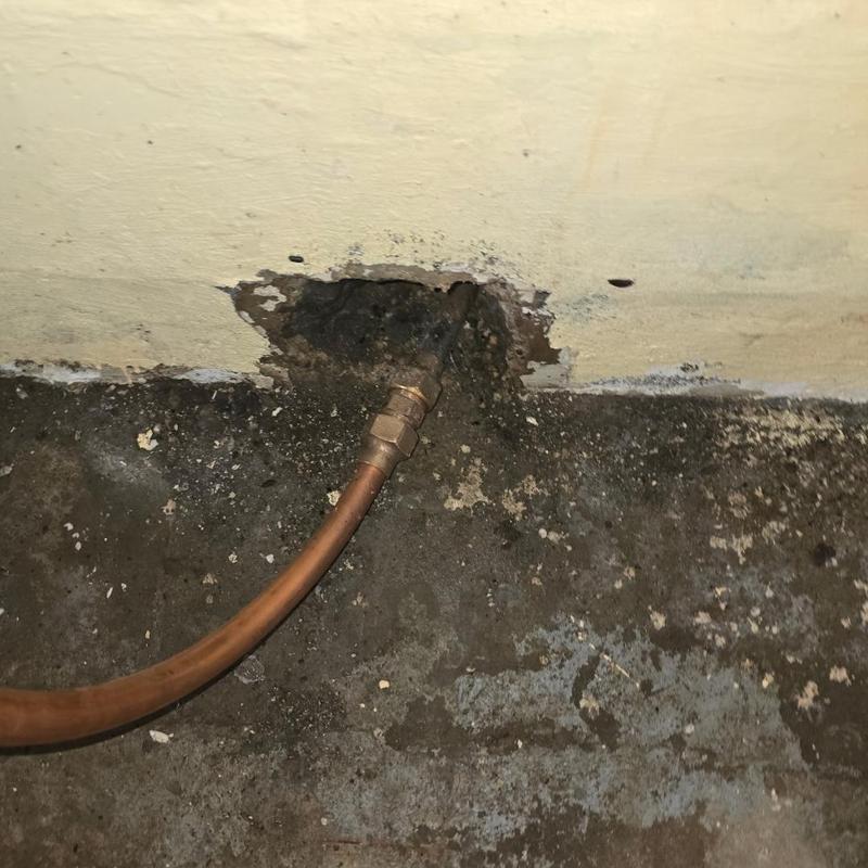 Copper water service line with wall penetration in basement