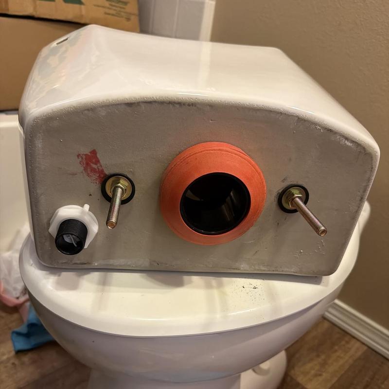Toilet tank with new gaskets and bolts installed