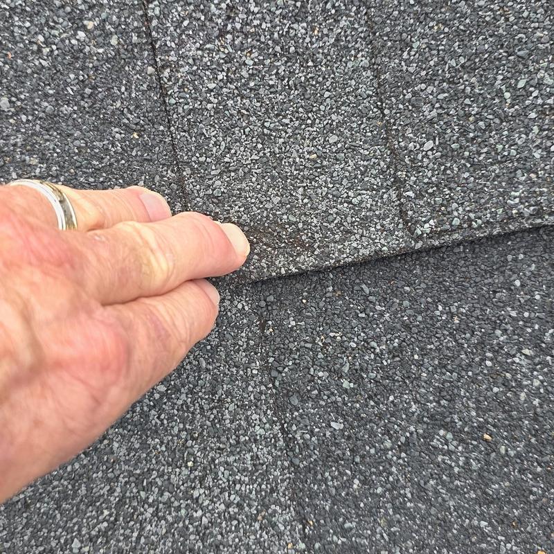 Asphalt roof shingles showing hail damage close-up