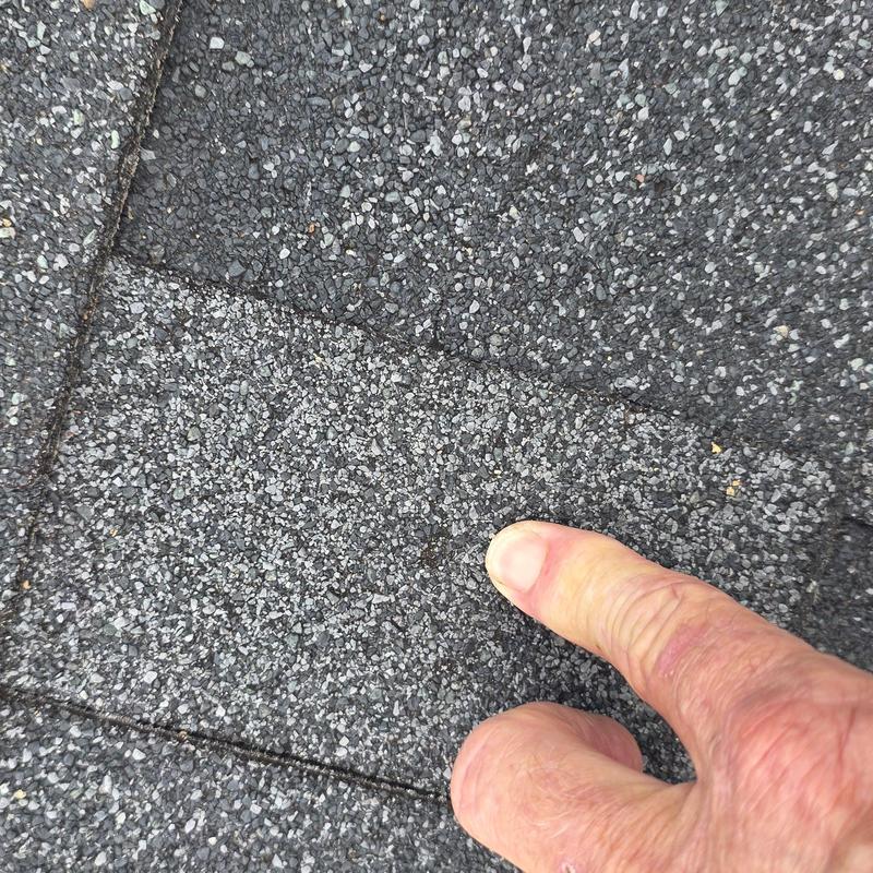 Asphalt roof shingles with hail damage close-up
