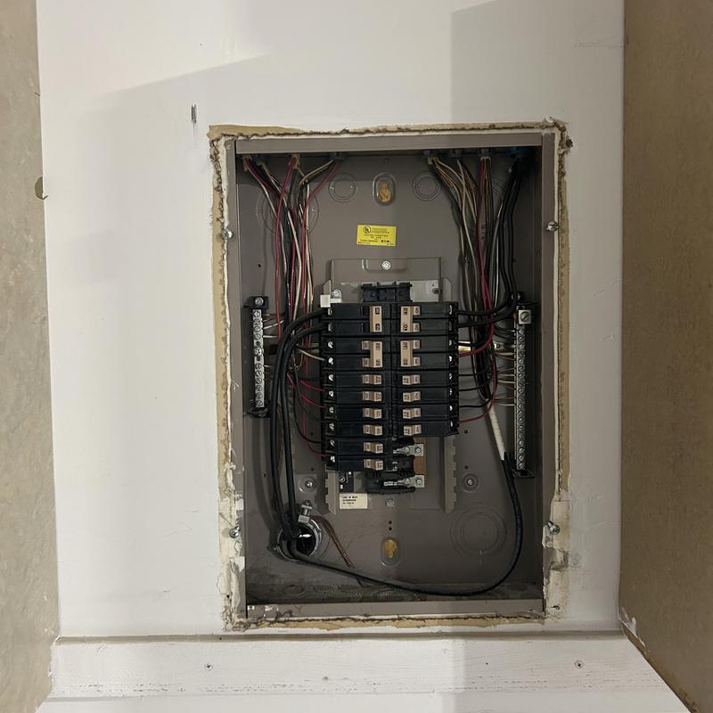Electrical circuit breaker panel with wiring inside wall cavity