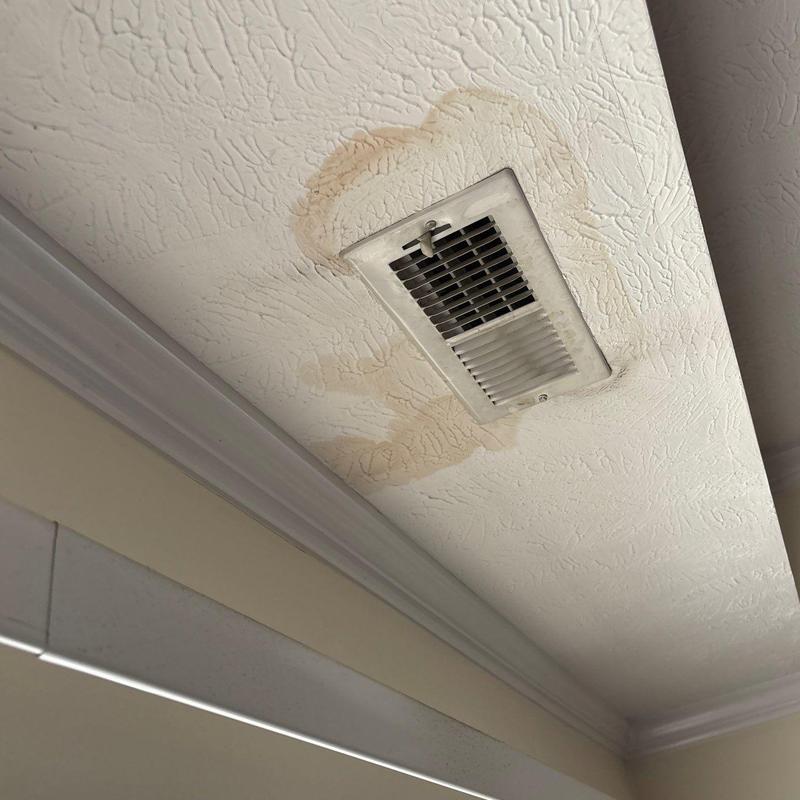Ceiling vent with water stains and damage