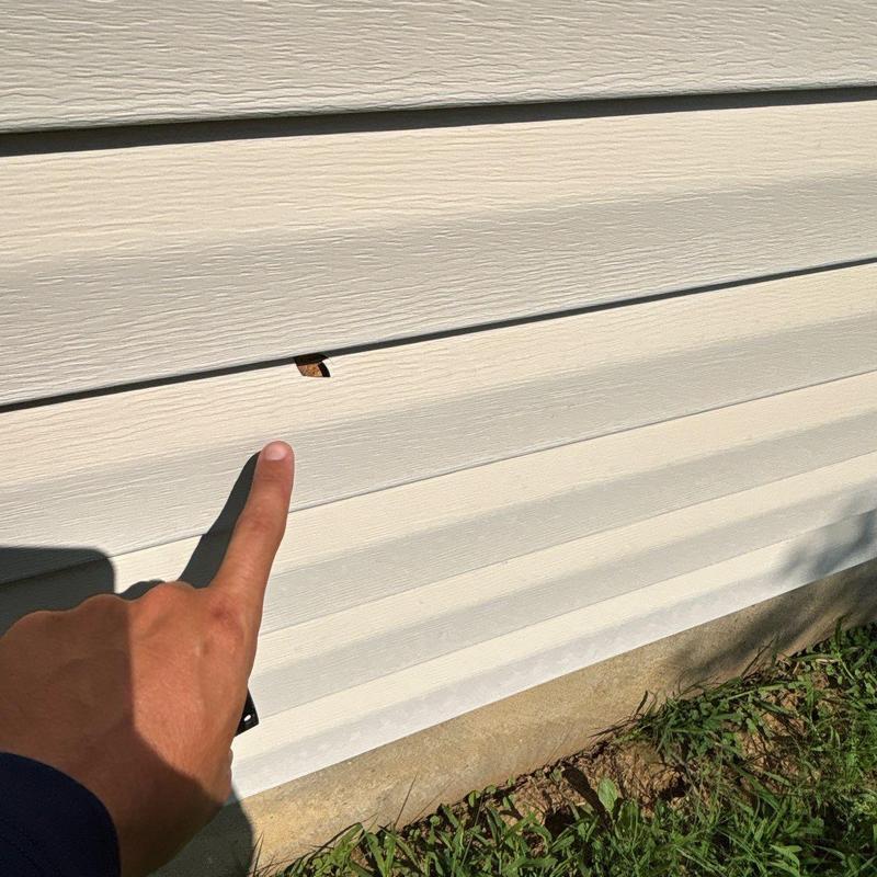Vinyl siding with small hole damage and finger pointing