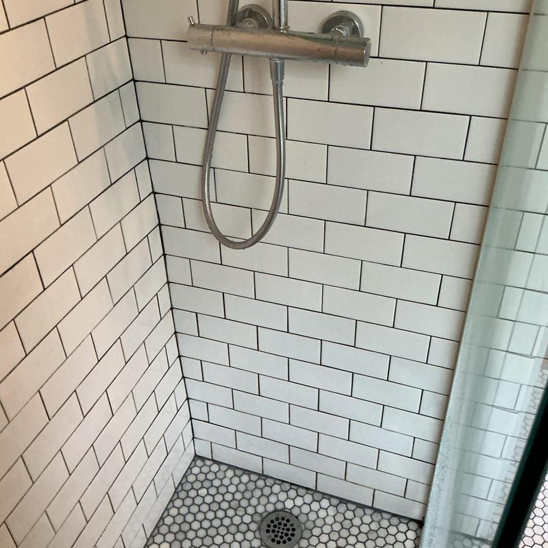Shower drain and tile with chrome shower fixture Shower drain and tile with chrome shower fixture