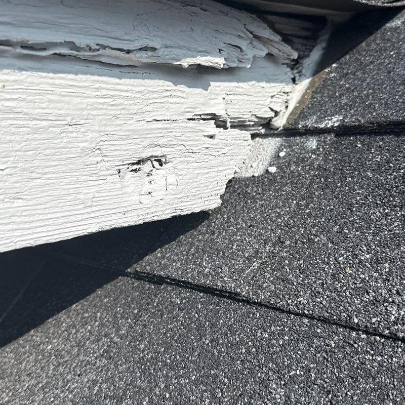 Roof edge wood rot and shingle hail damage close-up