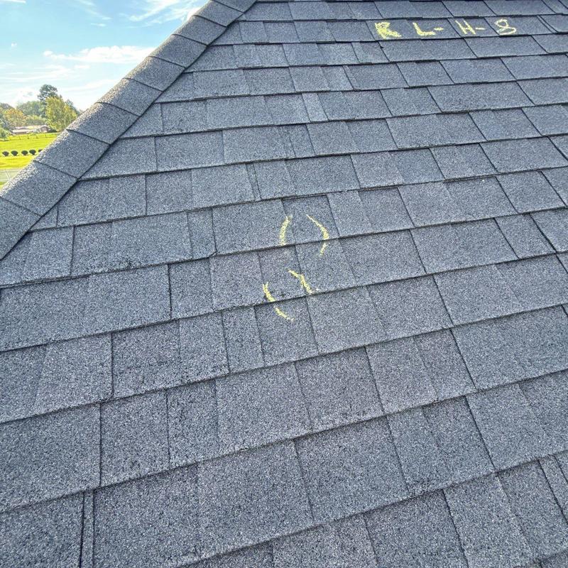 Asphalt roof shingles with hail damage markings