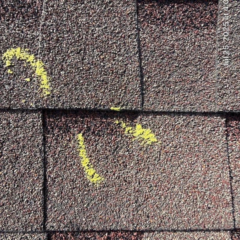 Asphalt shingles with hail damage marked for repair