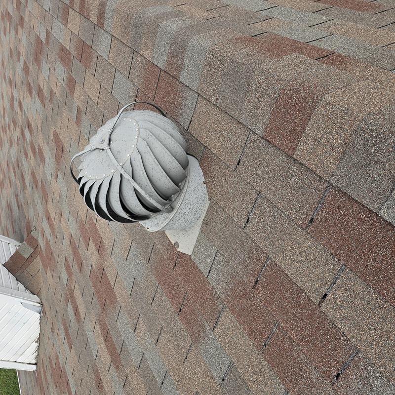 Roof turbine vent on asphalt shingle roof with hail damage