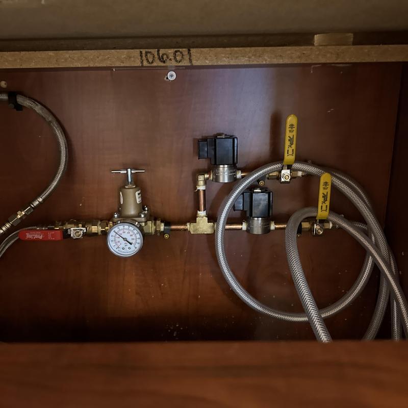 Water manifold with pressure gauge and valves under cabinet