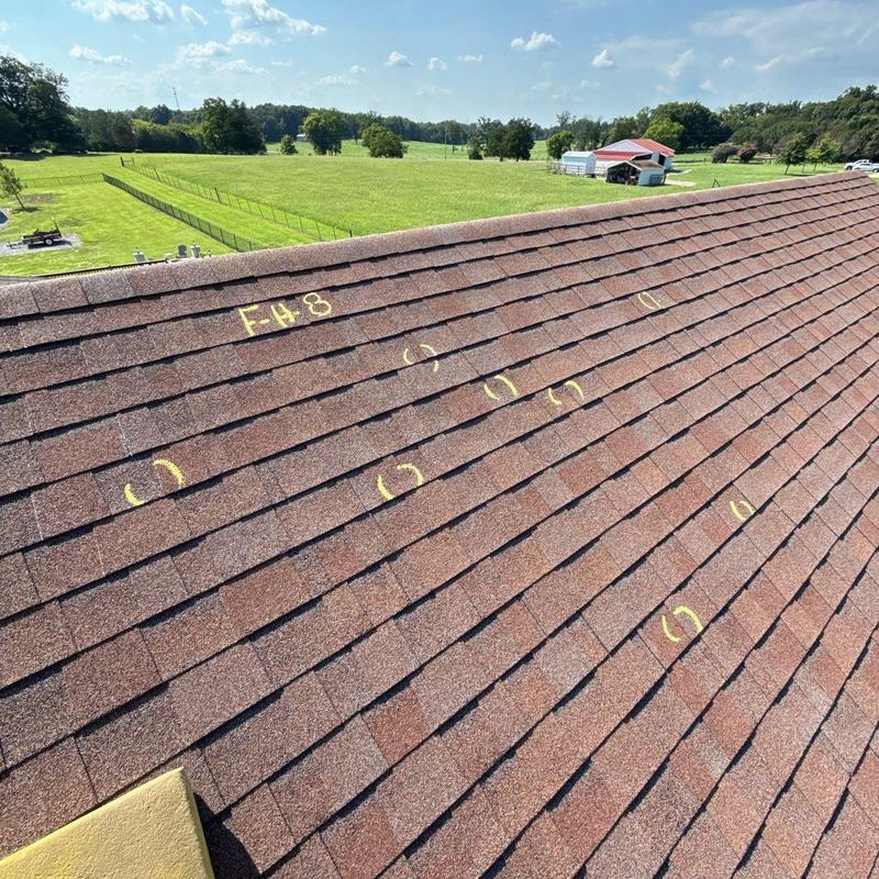 Asphalt shingles with hail damage markings on roof