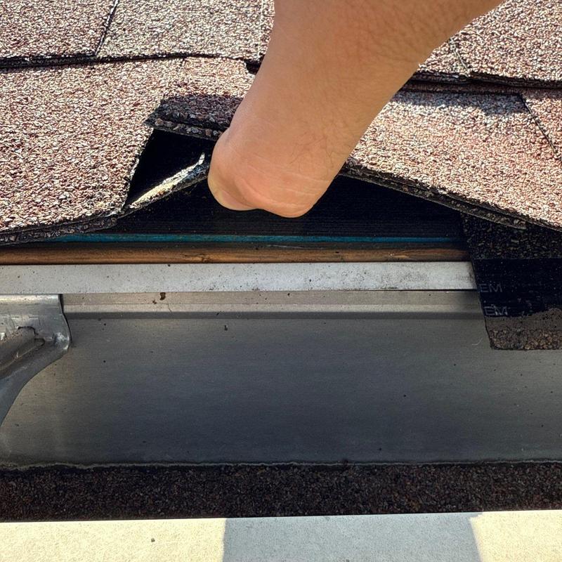 Asphalt shingle roof with lifted flashing and hail damage