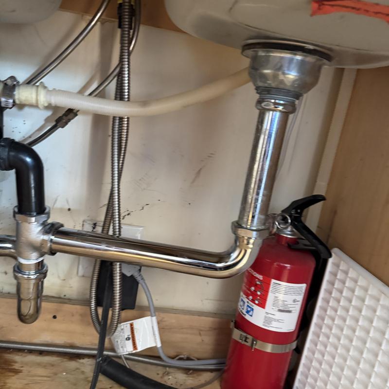 Kitchen sink drain pipe with fire extinguisher nearby