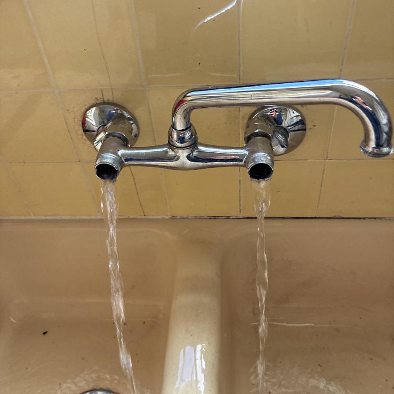 Kitchen faucet with flowing water after pressure repair