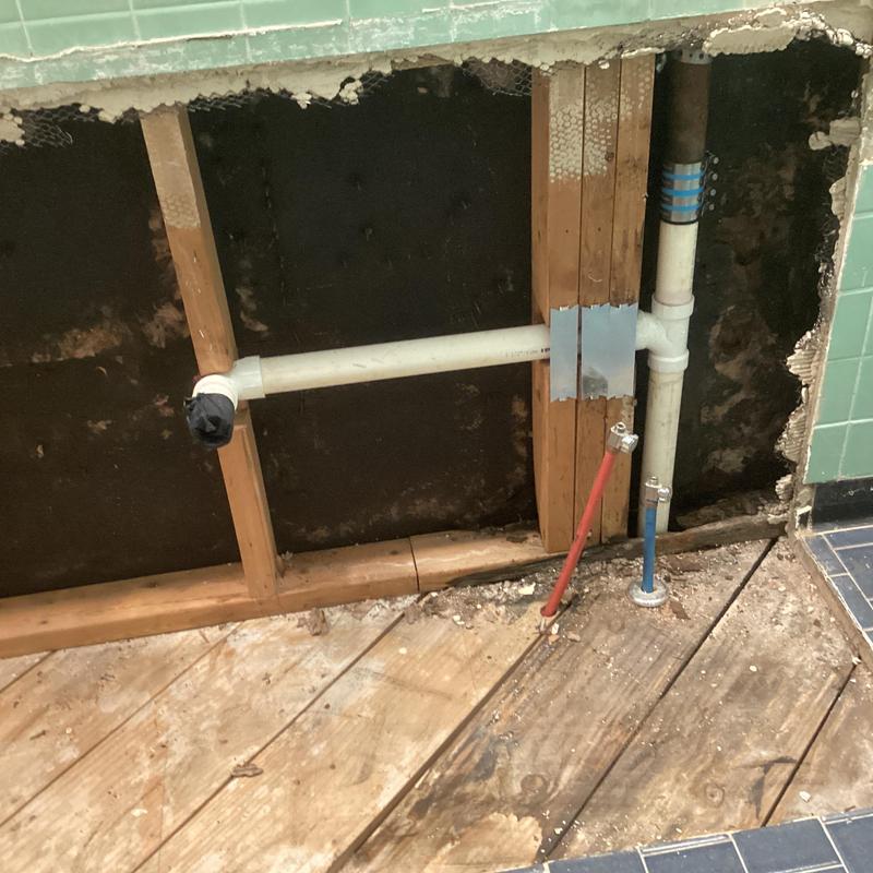 PVC drain pipe and water lines in wall cavity exposed