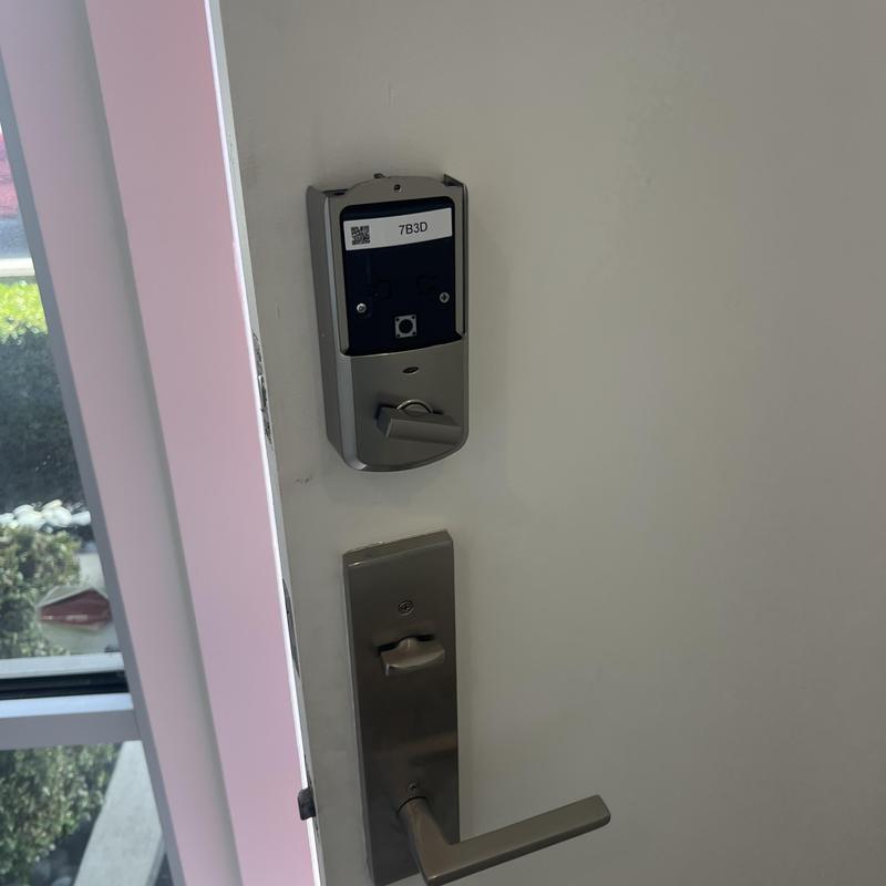 Electronic keypad lock housing on white door panel