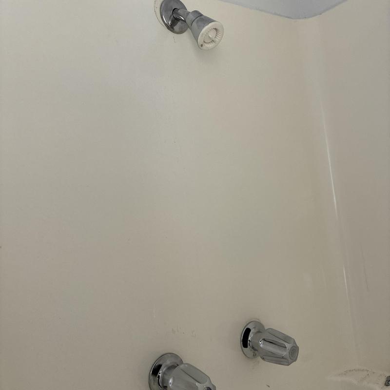 Shower faucet and handles in beige tub surround