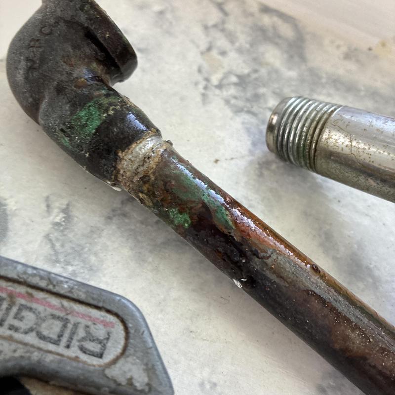 Copper plumbing pipe with corrosion and rust damage