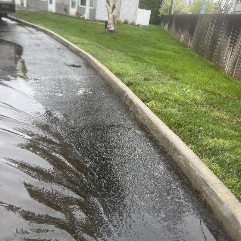 Stormwater drainage along residential curb and lawn Stormwater drainage along residential curb and lawn