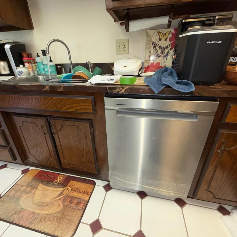 Dishwasher installation in kitchen with wood cabinets