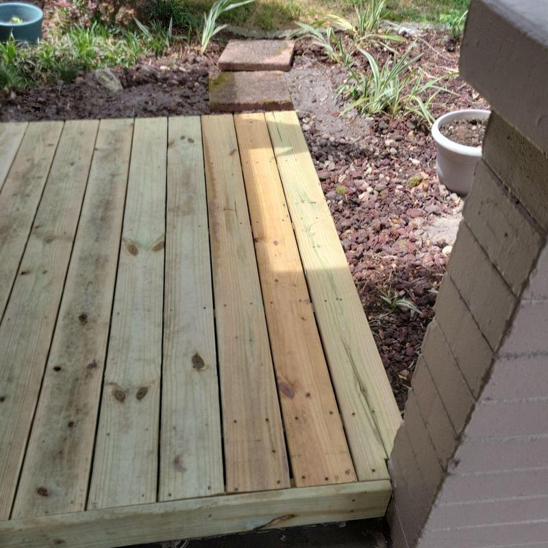 Pressure-treated wooden deck boards with fresh replacements