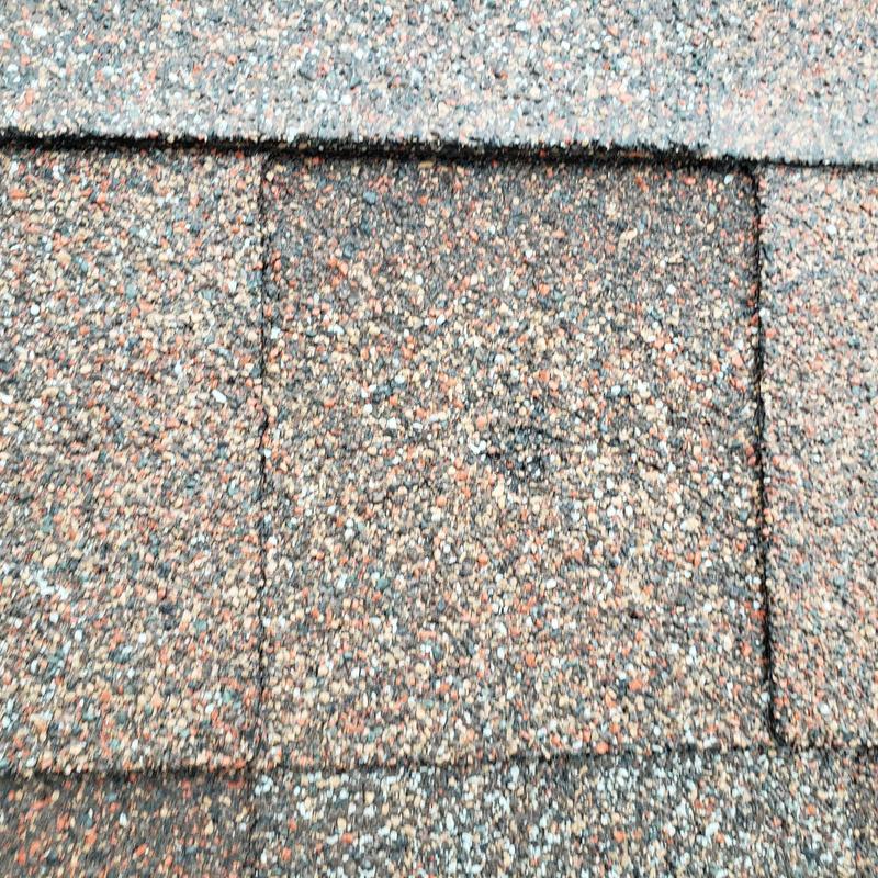 Asphalt shingle roof with hail damage close-up