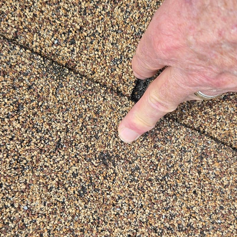 Asphalt shingle roof showing hail damage granules loss