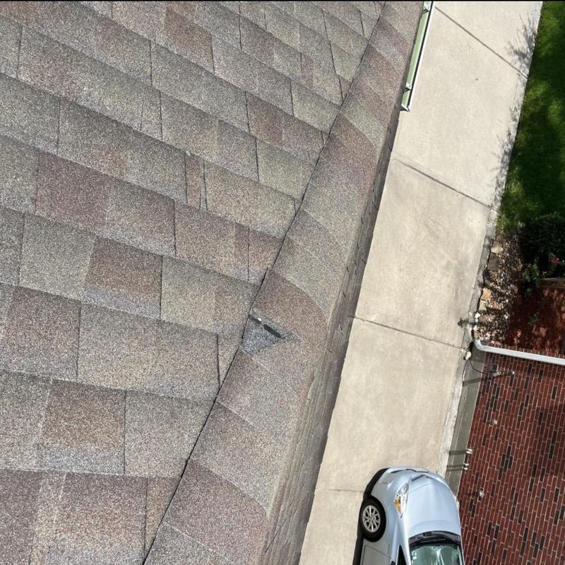Asphalt roof shingles with damaged ridge cap and wear