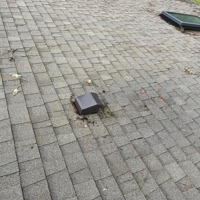 Flapper vent on roof with damaged shingles